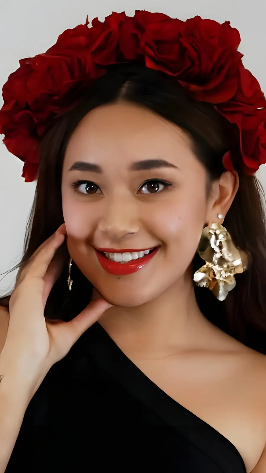A candidate wearing a crown of red roses and gold earrings